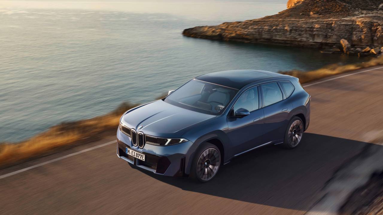 Grå BMW iX3 set skråt forfra i solnedgang